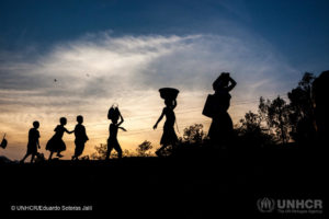 Women and children walk at sunset on a road near Uvira, Democratic Republic of the Congo (DRC), one of the main transit points for Burundian refugees crossing the border.