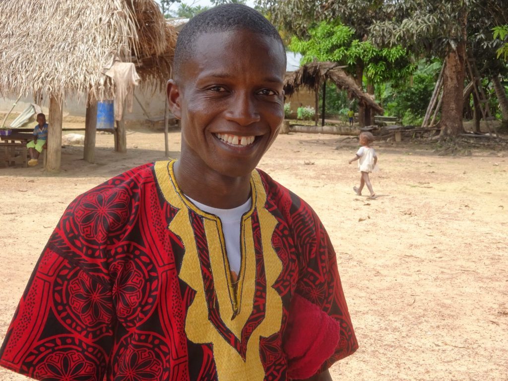 Liberialainen Pakolaisavun fasilitaattori hymyilee kameralle