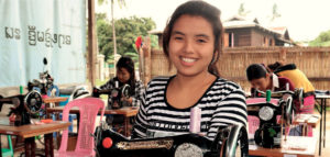 Myanmarilainen Ma Shar Mel istuu ompelukoneen äärellä Pakolaisavun ompelukurssilla