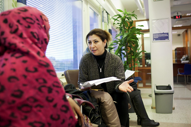 Pakolaisavun työntekijä Maryam Fathollahi opastaa asiakasta.