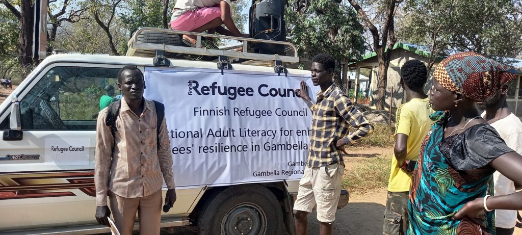 Kuvassa on Suomen Pakolaisavun logolla varustettu ajoneuvo ja sen ympärillä paikallisia ihmisiä Etiopiassa.
