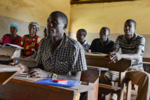 Ugandalaisia opiskelijoita istuu luokassa