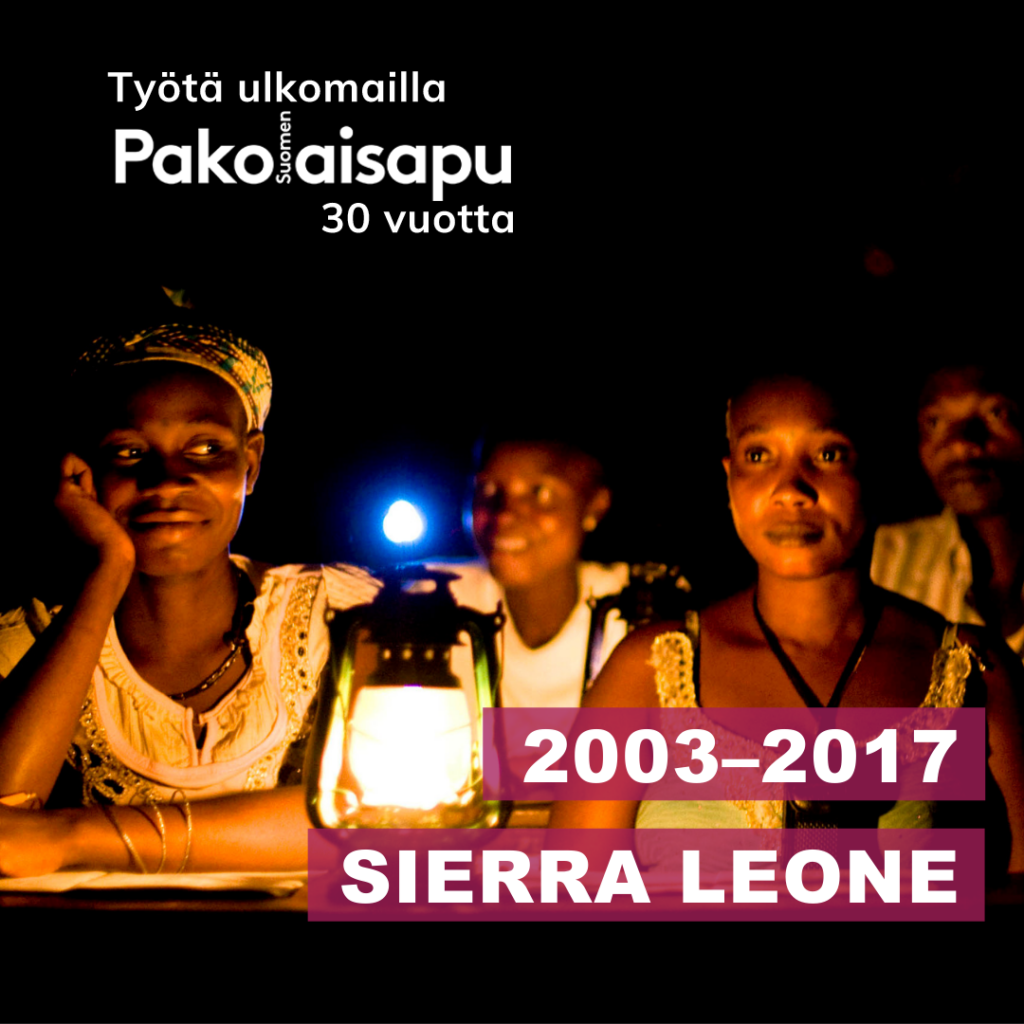 Ihmisiä istumassa öljylampun valossa. Kuvassa on Pakolaisapu, työtä ulkomailla 30 vuotta -logo ja teksti Sierra Leone 2003-2017.