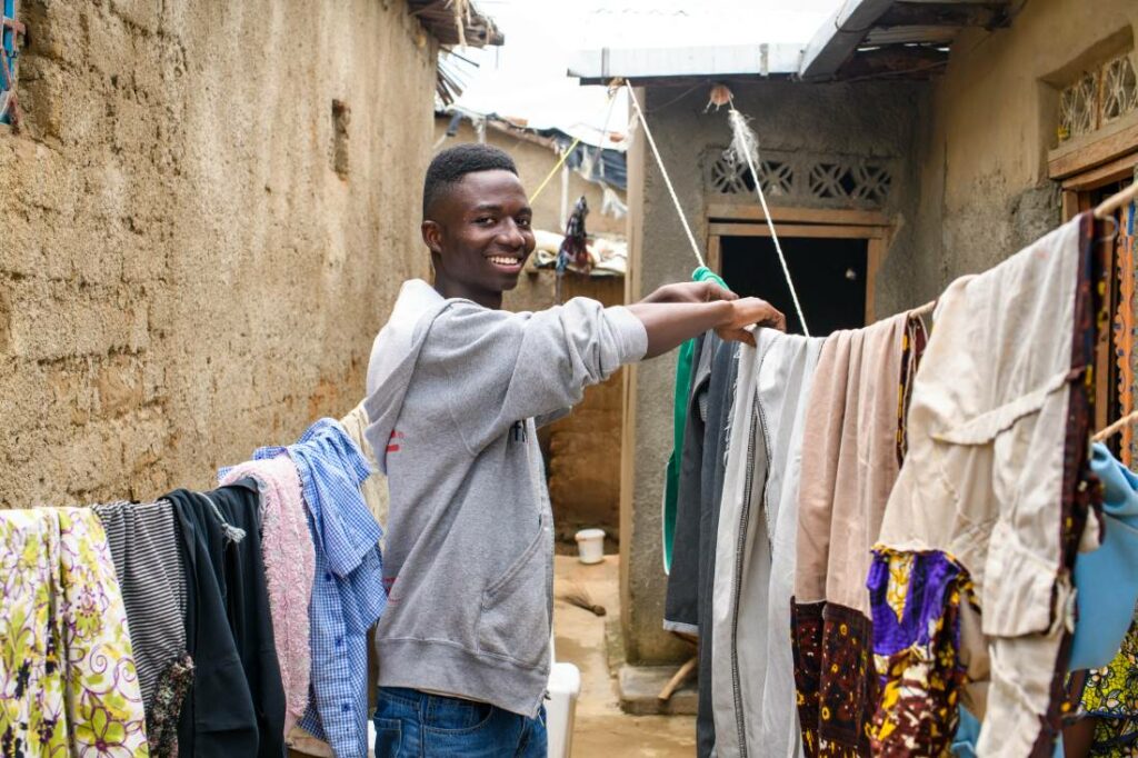 Kuvassa Masha Kashindi ripustamassa pyykkejä Ugandassa Nakivalen pakolaisalueella.