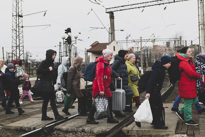 Ukrainalaisia kävelemässä tavaroiden kanssa junaradan yli