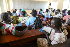 Kuvassa pakolaisia luokkahuoneessa Ugandassa.
