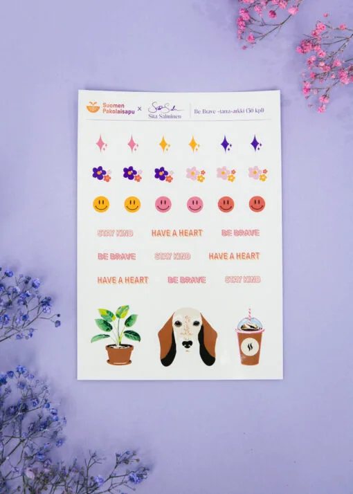 Kuvassa on violetilla pohjalla tarra-arkki, jossa on useita pieniä kuvio- ja tekstitarroja.