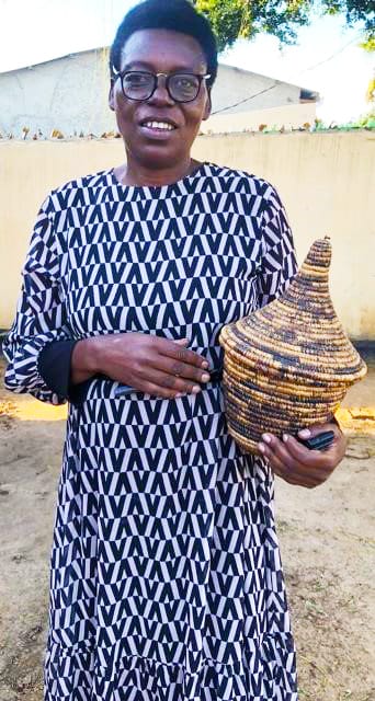 Petronille Mukandora posing with some of the handcraft products made at WENZETU training center on 21.5.2025 at her training center in Sangano village Nakivale settlement.